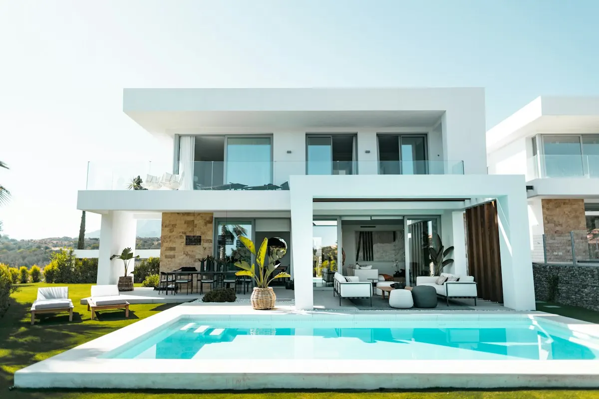 Casa branca de dois pavimentos com piscina e jardim